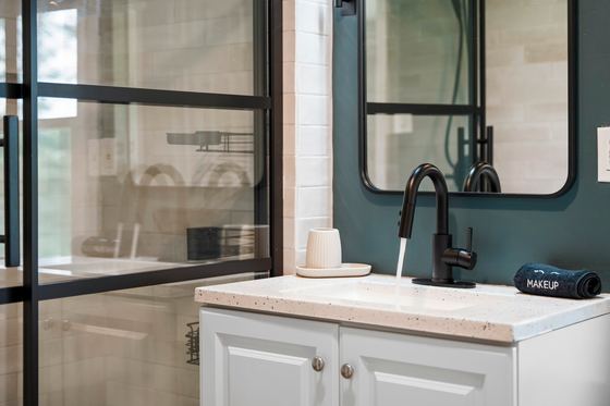 Bathroom vanity and mirror with a makeup counter.