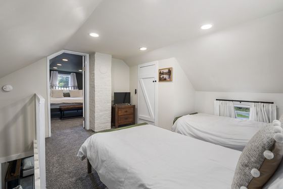 Loft twin beds with a mirror and dresser.