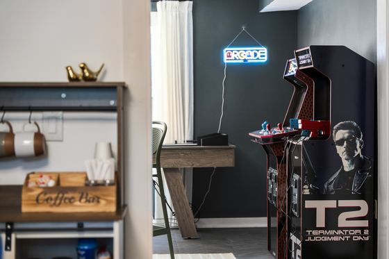 Coffee bar beside an arcade cabinet in the game room.